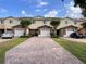 Charming townhomes with brick-paved driveways, stone accents, and lush landscaping under a sunny sky at 10116 Shadow Leaf Ct, Orlando, FL 32825