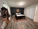 Primary bedroom with accent wall, wood-look floors, walk-in closet, and modern lighting at 10116 Shadow Leaf Ct, Orlando, FL 32825