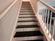 Carpet-free stairs with white risers and handrail, paired with contrasting black treads at 10116 Shadow Leaf Ct, Orlando, FL 32825