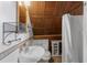 Attic bathroom featuring white pedestal sink, toilet, and shower with charming blue-tiled accents at 1018 Jersey Ave, St Cloud, FL 34769
