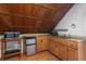 Attic kitchenette featuring a microwave, mini-fridge, counter space, and sink set under a wood paneled ceiling at 1018 Jersey Ave, St Cloud, FL 34769