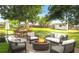 Inviting backyard with an outdoor dining set, a fire pit with comfortable seating, mature trees, and lush lawn at 1018 Jersey Ave, St Cloud, FL 34769