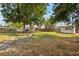 Expansive backyard featuring a fire pit, mature trees, and a view of the home's exterior at 1018 Jersey Ave, St Cloud, FL 34769