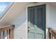 Exterior shot of a quaint green door with glass panels, set against a backdrop of white siding at 1018 Jersey Ave, St Cloud, FL 34769