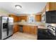 Kitchen with stainless steel appliances, wood cabinets, tile flooring, and natural lighting at 1018 Jersey Ave, St Cloud, FL 34769