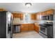 Kitchen with stainless steel appliances, wood cabinets, and tile flooring at 1018 Jersey Ave, St Cloud, FL 34769