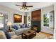 Cozy living room features a fireplace, a ceiling fan, and natural light from windows at 1018 Jersey Ave, St Cloud, FL 34769