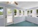 Bright sun room with beadboard walls, aqua-blue floors, and multiple windows offering lots of natural light at 1018 Jersey Ave, St Cloud, FL 34769
