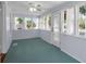 Bright sun room with beadboard walls, aqua-blue floors, and multiple windows offering lots of natural light at 1018 Jersey Ave, St Cloud, FL 34769