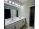 Modern bathroom featuring double sinks, quartz countertops, and sleek gray tile flooring at 12253 S Bracco St, Winter Garden, FL 34787