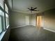 Spacious bedroom featuring a tray ceiling, ceiling fan, and ample natural light from large windows at 12253 S Bracco St, Winter Garden, FL 34787