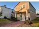 Charming two-story home featuring a welcoming front porch, landscaped yard, and neutral color palette at 12253 S Bracco St, Winter Garden, FL 34787