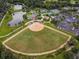 Aerial view of the community with baseball field, tennis courts, lake, and multiple amenities at 130 Los Gatos Pl, Kissimmee, FL 34759