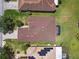 Aerial view of a well-maintained home with a brown roof and a screened-in pool area at 130 Los Gatos Pl, Kissimmee, FL 34759