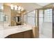 Bright bathroom featuring a spacious vanity, large mirror, and walk-in shower with glass enclosure at 130 Los Gatos Pl, Kissimmee, FL 34759