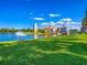 Picturesque view of a building across a lake with a fountain and colorful rainbow at 130 Los Gatos Pl, Kissimmee, FL 34759