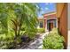 A welcoming entrance with a stone path and lush landscaping leads to a screened front door at 130 Los Gatos Pl, Kissimmee, FL 34759