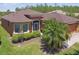 Front exterior with lush landscaping and a well-manicured lawn on a sunny day at 130 Los Gatos Pl, Kissimmee, FL 34759