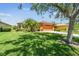 Beautiful home featuring a well-manicured lawn, mature trees, and an orange two-car garage at 130 Los Gatos Pl, Kissimmee, FL 34759