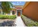 Inviting front entrance with a brick walkway, manicured shrubs, and warm lighting at 130 Los Gatos Pl, Kissimmee, FL 34759