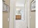 Hallway view leading to a well-lit bathroom featuring a shower and wooden vanity with white countertop at 130 Los Gatos Pl, Kissimmee, FL 34759