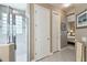 Hallway leading to a bathroom with a glass-enclosed shower and a bedroom with neutral decor and a ceiling fan at 130 Los Gatos Pl, Kissimmee, FL 34759