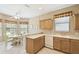 Open kitchen with ample counter space, wood cabinets, dishwasher, and tile flooring at 130 Los Gatos Pl, Kissimmee, FL 34759