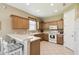 Well-lit kitchen with oak cabinets, white appliances, and breakfast bar seating at 130 Los Gatos Pl, Kissimmee, FL 34759