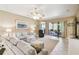 A spacious living room featuring comfortable seating, a ceiling fan, and sliding doors to the outdoor patio at 130 Los Gatos Pl, Kissimmee, FL 34759