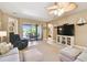 A cozy living room with a ceiling fan, TV, and sliding glass doors to the patio at 130 Los Gatos Pl, Kissimmee, FL 34759