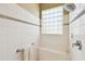Shower featuring white tiling, a comfortable bench, and a unique glass block window for natural light at 130 Los Gatos Pl, Kissimmee, FL 34759