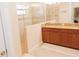 Bathroom features a double vanity with granite countertops and tiled glass shower with half wall at 1302 Moss Creek Ln, Davenport, FL 33896