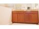 Bathroom features a double vanity with granite countertops and wood cabinets at 1302 Moss Creek Ln, Davenport, FL 33896