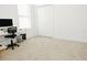 Clean, carpeted bedroom with a large window, white walls, closet, and desk space for convenience at 1302 Moss Creek Ln, Davenport, FL 33896