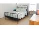 Cozy bedroom featuring a black metal bed frame, neutral decor and light-filled window at 1302 Moss Creek Ln, Davenport, FL 33896