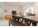 Well-lit dining area that features a modern table, chairs and bench; kitchen in background at 1302 Moss Creek Ln, Davenport, FL 33896