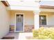 Charming home entrance with a grey front door, stone accents, and landscaped bushes at 1302 Moss Creek Ln, Davenport, FL 33896