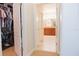 Hallway with closet on the left and bathroom with cherry cabinets and double sinks at the end at 1302 Moss Creek Ln, Davenport, FL 33896