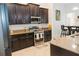 Modern kitchen with stainless steel appliances, granite countertops and rich, dark cabinetry at 1302 Moss Creek Ln, Davenport, FL 33896