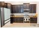 Modern kitchen with stainless steel appliances, granite countertops and rich, dark cabinetry at 1302 Moss Creek Ln, Davenport, FL 33896