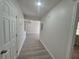 Neutral hallway with gray flooring leads to open living spaces, promoting seamless flow and accessibility at 139 Arroyo Pkwy, Ormond Beach, FL 32174