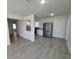 Open-concept living area flows into kitchen with modern stainless steel appliances and gray vinyl flooring at 139 Arroyo Pkwy, Ormond Beach, FL 32174