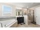The bathroom has a soaking tub, glass shower, and vanity with great natural light at 1443 Bunker Dr, Davenport, FL 33836