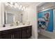 Bathroom with double sink vanity and shower/tub combination with cute shower curtain at 1443 Bunker Dr, Davenport, FL 33836