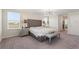 Comfortable bedroom featuring a tufted headboard, neutral tones, and ample natural light at 1443 Bunker Dr, Davenport, FL 33836