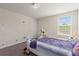This small bedroom with carpet floors has a sunny window and whimsical decor at 1443 Bunker Dr, Davenport, FL 33836