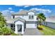 Charming two-story home with a well-manicured lawn, stone accents, and a paver driveway at 1443 Bunker Dr, Davenport, FL 33836