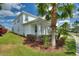 Side view of a two-story home with palm trees and landscaped yard, showcasing a serene setting at 1443 Bunker Dr, Davenport, FL 33836