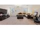 Cozy living room featuring a sectional sofa, carpeted floors, and modern lighting at 1443 Bunker Dr, Davenport, FL 33836