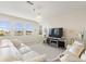 Bright living room featuring a white leather sectional, large windows, and stylish lighting at 1443 Bunker Dr, Davenport, FL 33836